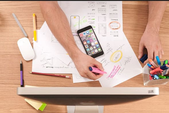 Person-Working-at-Desk-With-White-Documents-·-Free-Stock-Photo
