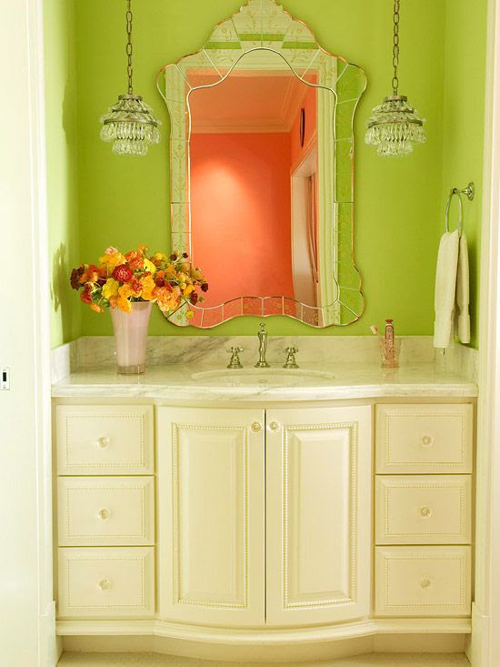 The antique inspired vanity, mirror, and hanging pendants combined with bright colored walls pull this tight elegant space together with some savvy style.