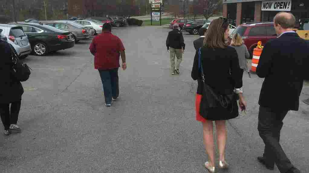 Reporters and campaign staffers rush to their cars to get to Hillary Clinton's first Iowa campaign stop.