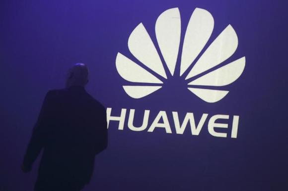 A man walks past a logo during the presentation the Huawei's new smartphone, the Ascend P7, launched by China's Huawei Technologies in Paris, May 7, 2014. REUTERS/Philippe Wojazer