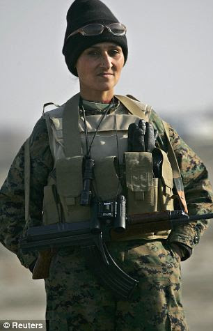 An Afghan woman soldier stands guard as officials prepare to burn seven tons of seized drugs on the outskirts of Kabul