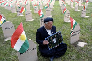 A resident of Halabja, Iraq holds a picture of his son at a cemetery for Kurdish poison gas victims on March 16, 2010. The 1988 attack killed several thousand people, with the precise death toll unknown. 