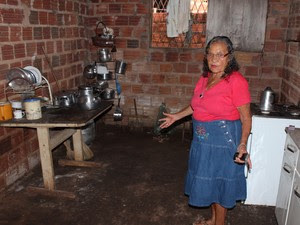 Maria mostra estrutura precária da cozinha de sua casa (Foto: Ellyo Teixeira/G1)