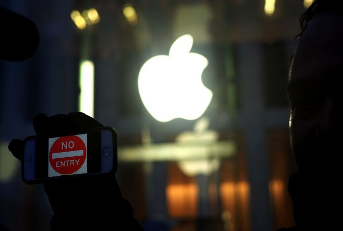 An anti-government protester holds up his iPhone with a sign "No Entry" during a demonstration near the Apple store on Fifth Avenue in New York on February 23, 2016. Apple is battling the US government over unlocking devices in at least 10 cases in addition to its high-profile dispute involving the iPhone of one of the San Bernardino attackers, court documents show. Apple has been locked in a legal and public relations battle with the US government in the California case, where the FBI is seeking technical assistance in hacking the iPhone of Syed Farook, a US citizen, who with his Pakistani wife Tashfeen Malik in December gunned down 14 people. / AFP / Jewel Samad (Photo credit should read JEWEL SAMAD/AFP/Getty Images)