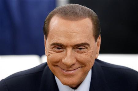 Former Prime Minister Silvio Berlusconi smiles before casting his vote at the polling station in Milan, February 24, 2013. REUTERS/Stefano Rellandini