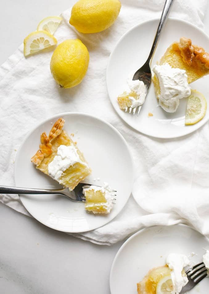 Lemon Olive Oil Pie Recipe by wood and spoon blog. This is a lemon zest and juice filled chess pie made with and olive oil pie crust. The flavor of the Lucini olive oil comes out subtly and perfumes this pie. The crust crisps nicely and the filled stays gooey and sweet like a lemon bar. Finish the pie off with freshly whipped cream. Read more about the recipe on thewoodandspoon.com