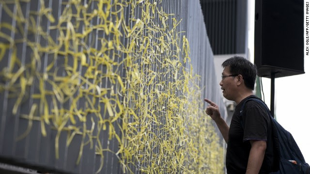 A pro-democracy activist shouts at police officers behind a fence with yellow ribbons on September 28. 
