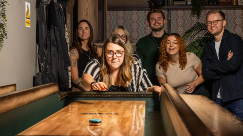 A group of people playing shuffleboard at Electric Shuffle