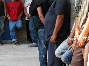 Suspected members of the Mara Salvatrucha gang under arrest at a San Salvador police station.  The 24 suspects were arrested in a police raid. Police officials say they're accused of major crimes including homicide, rape, extortion and drug possession.