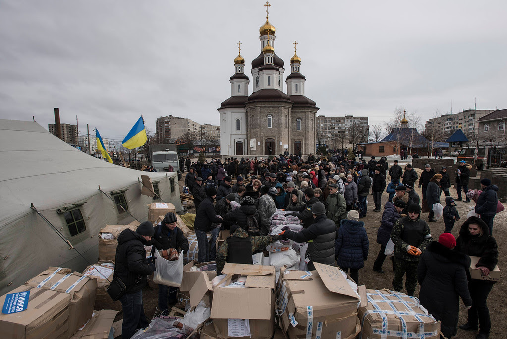Description of . Volunteers distribute humanitarian aid after Saturday's attacks, in Mariupol, Ukraine, Sunday, Jan. 25, 2015. Indiscriminate rocket fire slammed into a market, schools, homes and shops Saturday in Ukraine's southeastern city of Mariupol, killing at least 30 people, authorities said. The Ukrainian president called the blitz a terrorist attack and NATO and the U.S. demanded that Russia stop supporting the rebels. (AP Photo/Evgeniy Maloletka)
