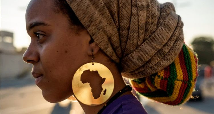 Profile of a Black woman with circular earring with silhouette of Africa
