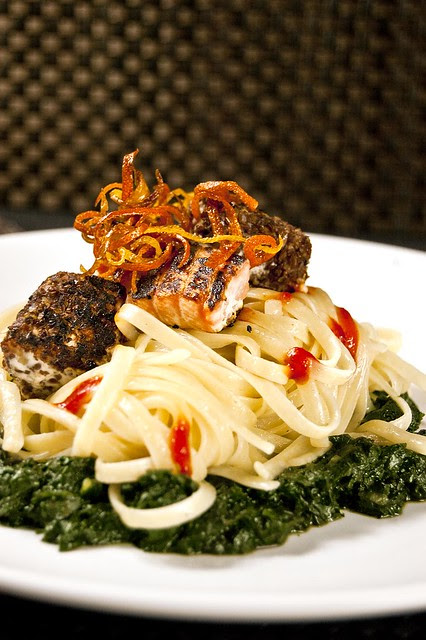 Citrusy-hot linguine on a bed of garlicky spinach served with seared salmon bits and garnished with crispy citrus zests