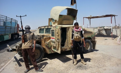 Iraqi insurgents militants stand with captured Iraqi army Himvee at a vehicle checkpoint.