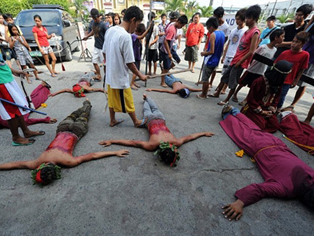 Penitentes são chicoteados nas celebrações filipinas da Semana Santa (Foto: Ted Aljibe/AFP)