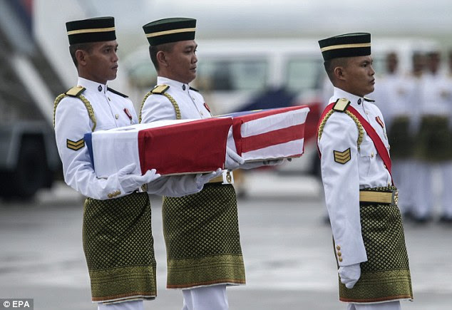 Twin tragedies: Malaysian army personnel carry the remains of victims who were aboard Flight MH17