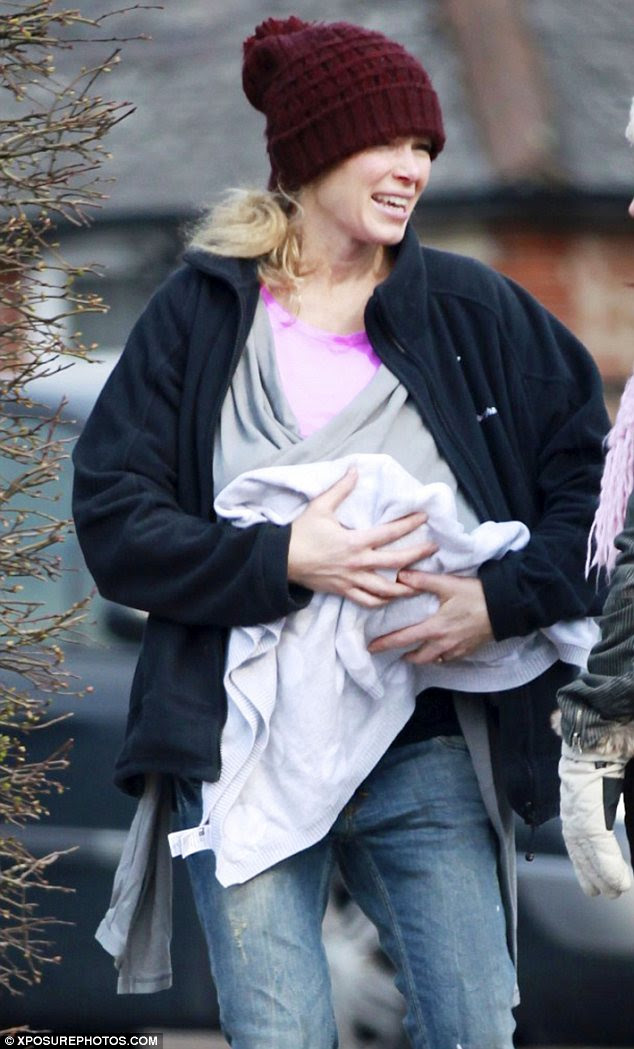 Are you sure there's a baby in there: Nell McAndrew cradled her baby daughter in an unorthodox fashion on Wednesday 