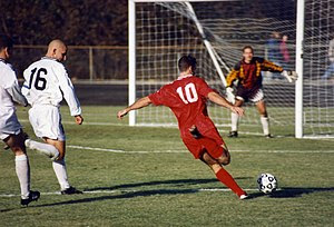 The striker (wearing the red shirt) is past th...