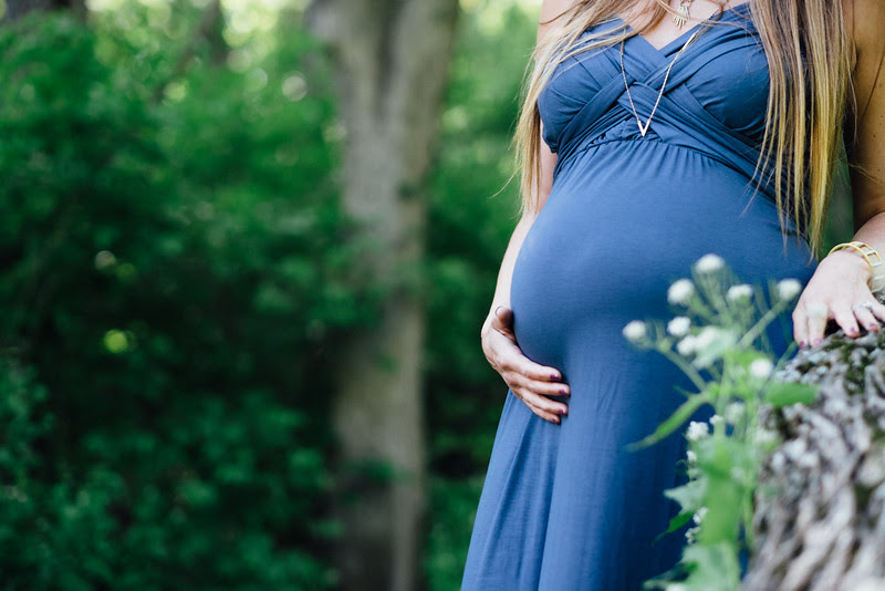 A late spring maternity photo session with a stunning mother-to-be in a beautiful outdoor location surrounded by gravel trails, a covered bridge, and large apple tree. We ended the session with Kacia standing in a shallow creek.