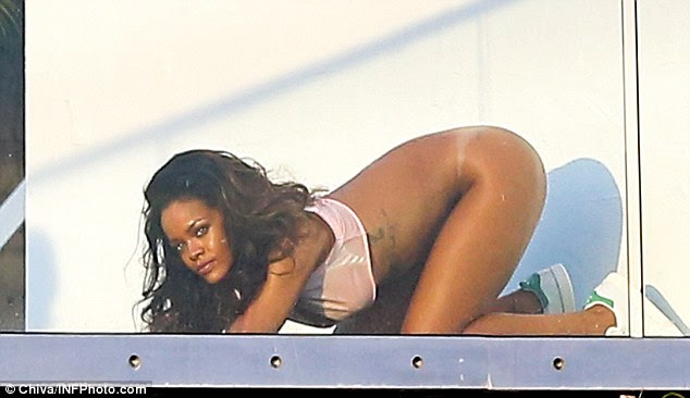 Golden goddess: Rihanna looked out to the horizon as the camera continued to snap away