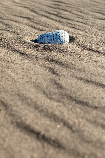 A rock in beach sand.