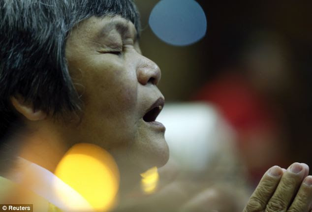A woman takes part in a special prayer for those missing aboard the flight. Investigators believe the flight veered off course and came down somewhere in the southern Indian Ocean