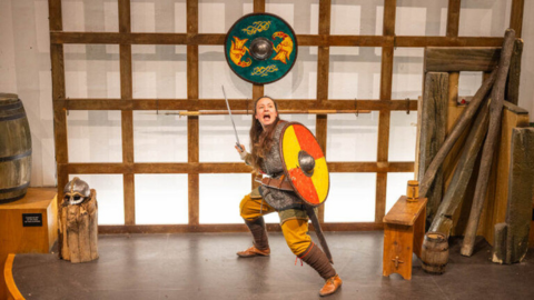 A woman posing with a shield and a sword