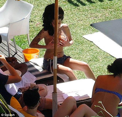 Quite a handful: Amy admires her own boobs as her friends and staff look on