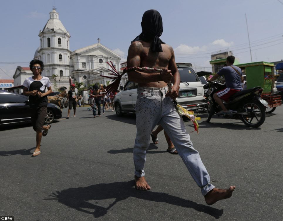Journey: The hooded and barefoot penitents in San Fernando lash their backs as they make their way along narrow roads which lead to a dusty hill, where other men dressed as Jesus Christ are nailed to wooden crosses