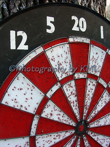 a well used red and white dart board