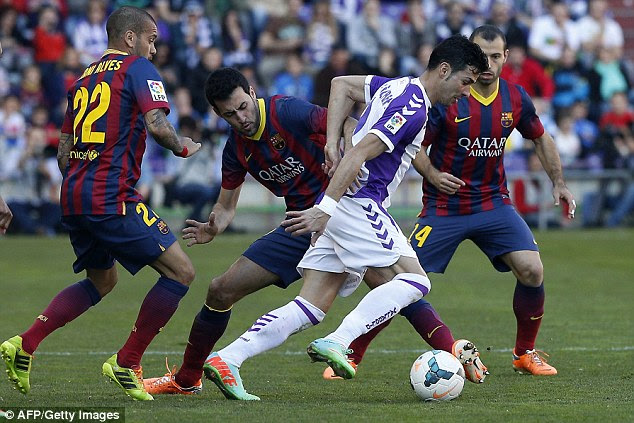 Surrounded: Valladolid forward Javi Guerra, right, attempts to get away from Barcelona duo Sergio Busquets, second left, and Brazilian defender Dani Alves