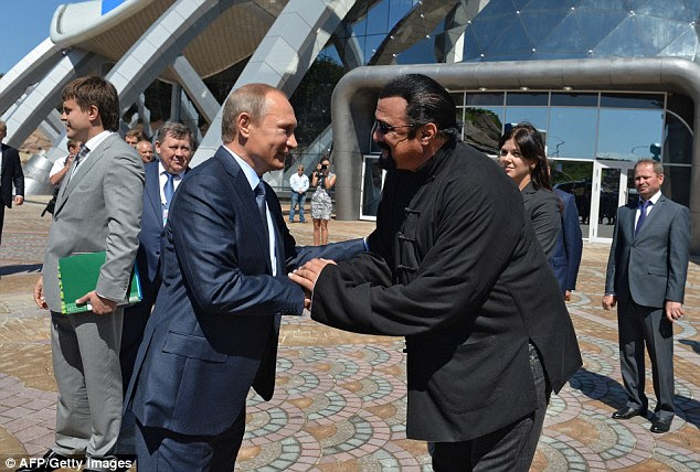Russian President Vladimir Putin shakes hands with movie actor Steven Seagal at the Russia's first ever Eastern Economic Forum (EEF) in Vladivostok