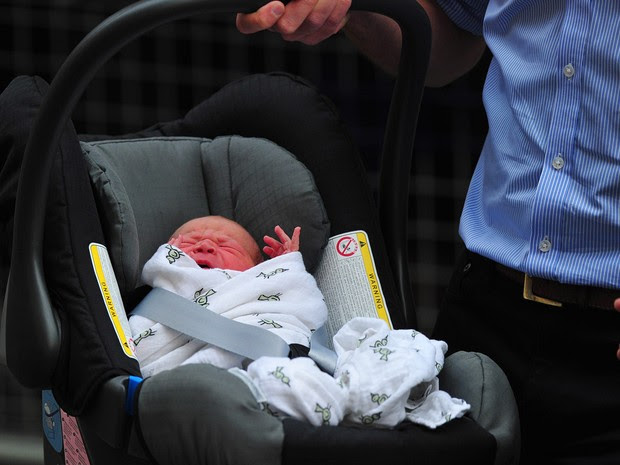 23/7 - William carrega seu filho para dentro do carro ao deixar o hospital (Foto: Carl Court/AFP)