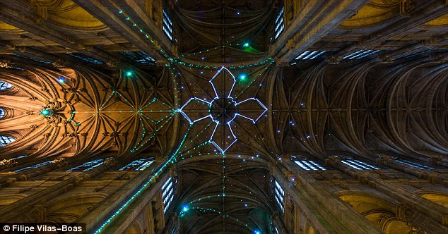 Sign of the cross: The lighting changes in response to text messages sent from people's smartphones, to a number used by the cathedral. Here, beams of light create a giant cross on the building's vaulted celing