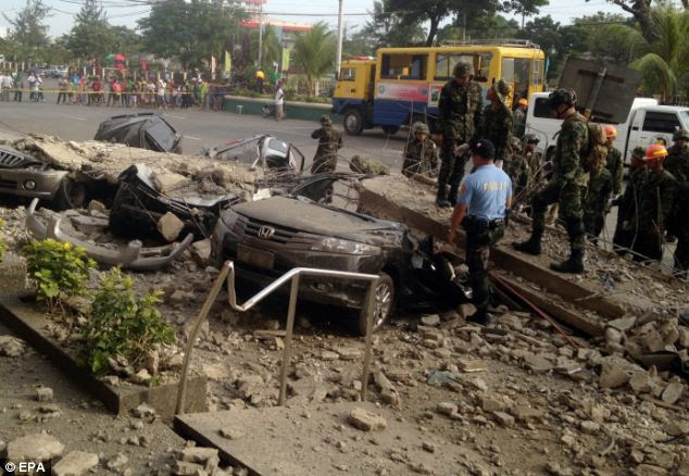 Looking for survivors: Filipino soldiers view damaged cars underneath rubble outside a shopping mall 