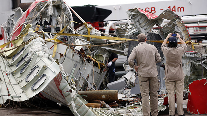 Airbus investigators examines part of the tail of AirAsia QZ8501 passenger plane in Kumai Port, near Pangkalan Bun, Central Kalimantan January 12, 2015. (Reuters/Darren Whiteside)