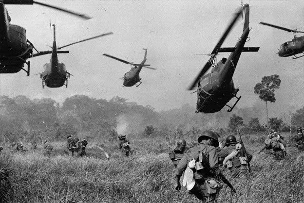 In this March 1965 file photo by Associated Press photographer Horst Faas, hovering U.S. Army helicopters pour machine gun fire into the tree line to cover South Vietnamese ground troops advancing on a Viet Cong camp northwest of Saigon. Faas' work in Vietnam won four major photo awards, including the first of his two Pulitzers. He was severely wounded there in 1967.