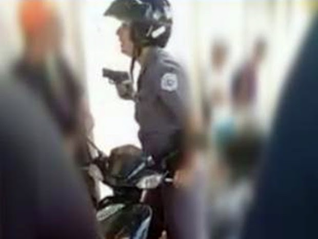 Momento em que a policial saca a arma para ameaçar estudante (Foto: Reprodução/ TV TEM)