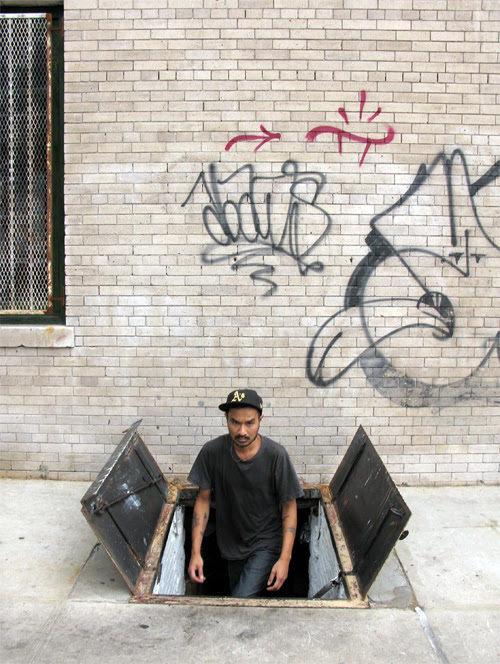 a man comes out of a trap door on a Brooklyn sidewalk, NYC
