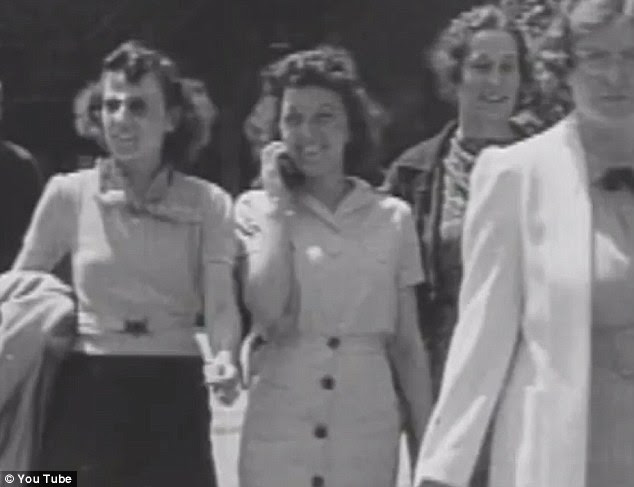 Ahead of her time: The woman is captured talking on the small modern looking device as she walks 