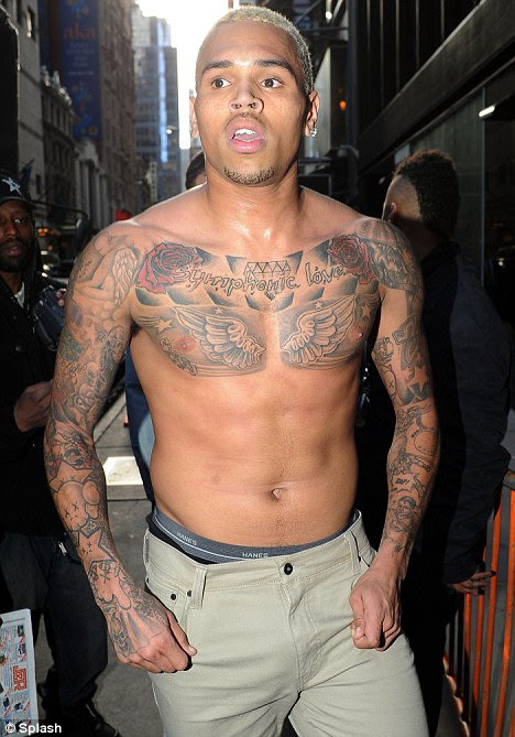 Wild eyed: Chris Brown emerged from the Good Morning America studios in New York this morning without his shirt after allegedly flying into a rage backstage