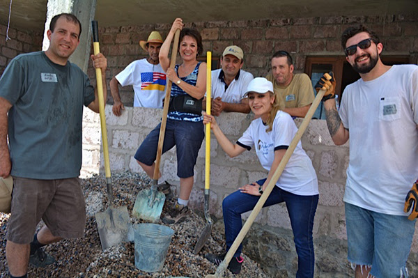 Team members, homeowner Archanik Simonyan (top left), and the Fuller Center staff get ready to prepare the concrete flooring