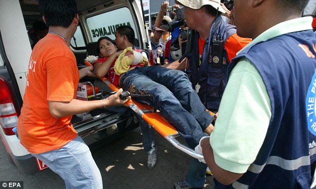 Help at hand: Red Cross volunters lift into an ambulance an injured female survivor of the ill-fated Super Ferry 9
