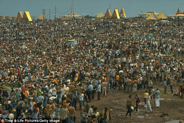 Peaceful masses: Overall image of the huge crowd, looking towards the large yellow tents, during the Woodstock Music & Art Fair
