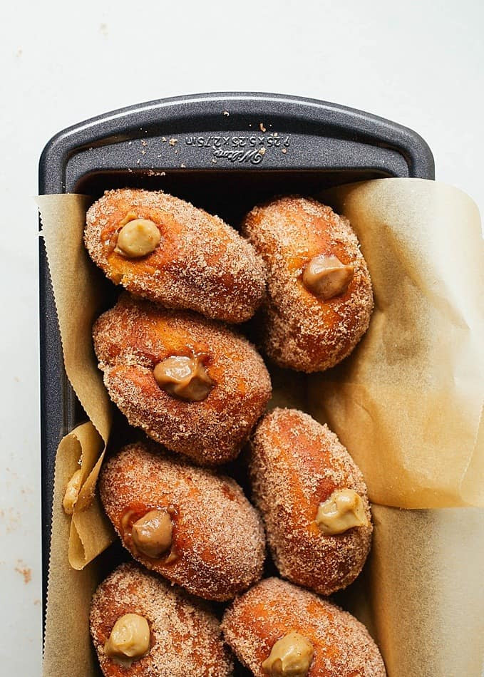 Coffee Donuts by Wood and Spoon blog. This is a recipe for cinnamon sugar doughnuts filled two ways- with a coffee / espresso custard or a coffee cream. For a sweeter taste, try the cream with a buttercream/ white cream filling. For a creamy mouthfeel and rich eclair filling, try the cooked custard make with eggs, milk, and butter. These fried doughnuts are delicious breakfast or brunch option! Find the recipe by Kate Wood on thewoodandspoon.com