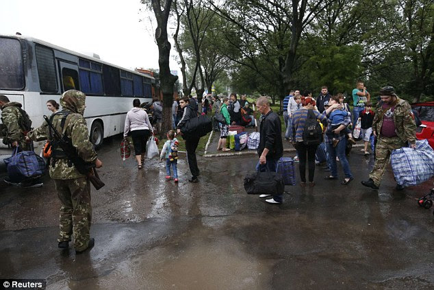 Residents of the Donetsk region in eastern Ukraine prepare to board buses for Rostov-on-Don in Russia from a collection point in Donetsk July 14, 2014. Russia threatened Ukraine on Sunday with "irreversible consequences" after a Russian man was killed by a shell fired across the border, while Kiev said Ukrainian warplanes struck again at separatist positions in the east of the country, inflicting big losses. REUTERS/Maxim Zmeyev (UKRAINE - Tags: POLITICS CIVIL UNREST)