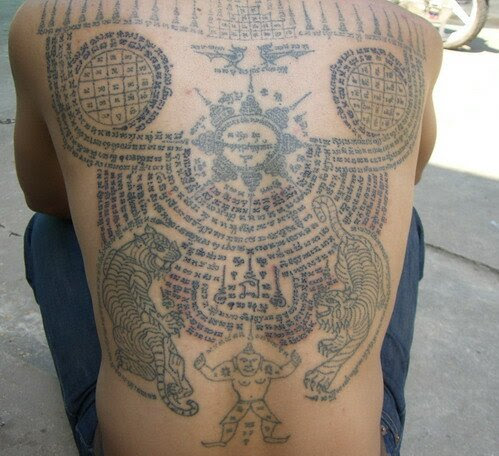 A man gets a tattoo on his back with Buddhist scriptures