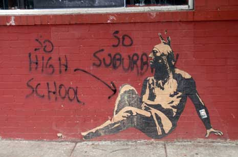 Graffiti critiquiing an image on a brick wall