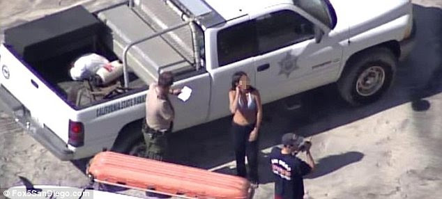 Safe at last: The woman finally gets all her clothes back on just before she gets ticketed by officers for ignoring signs and entering a restricted area