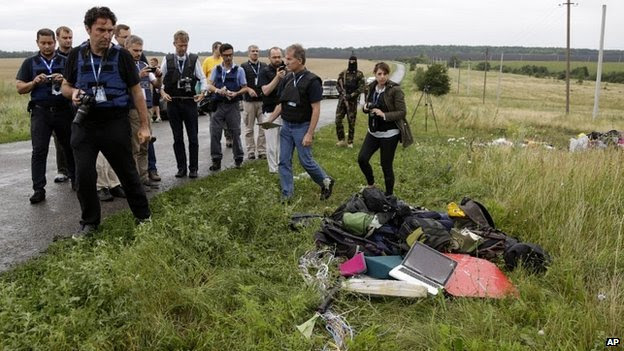 OSCE observers inspect the site of the crash in eastern Ukraine under the watchful eye of armed rebels - 18 July 2014