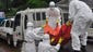 Health workers  load a body of a man who is suspected